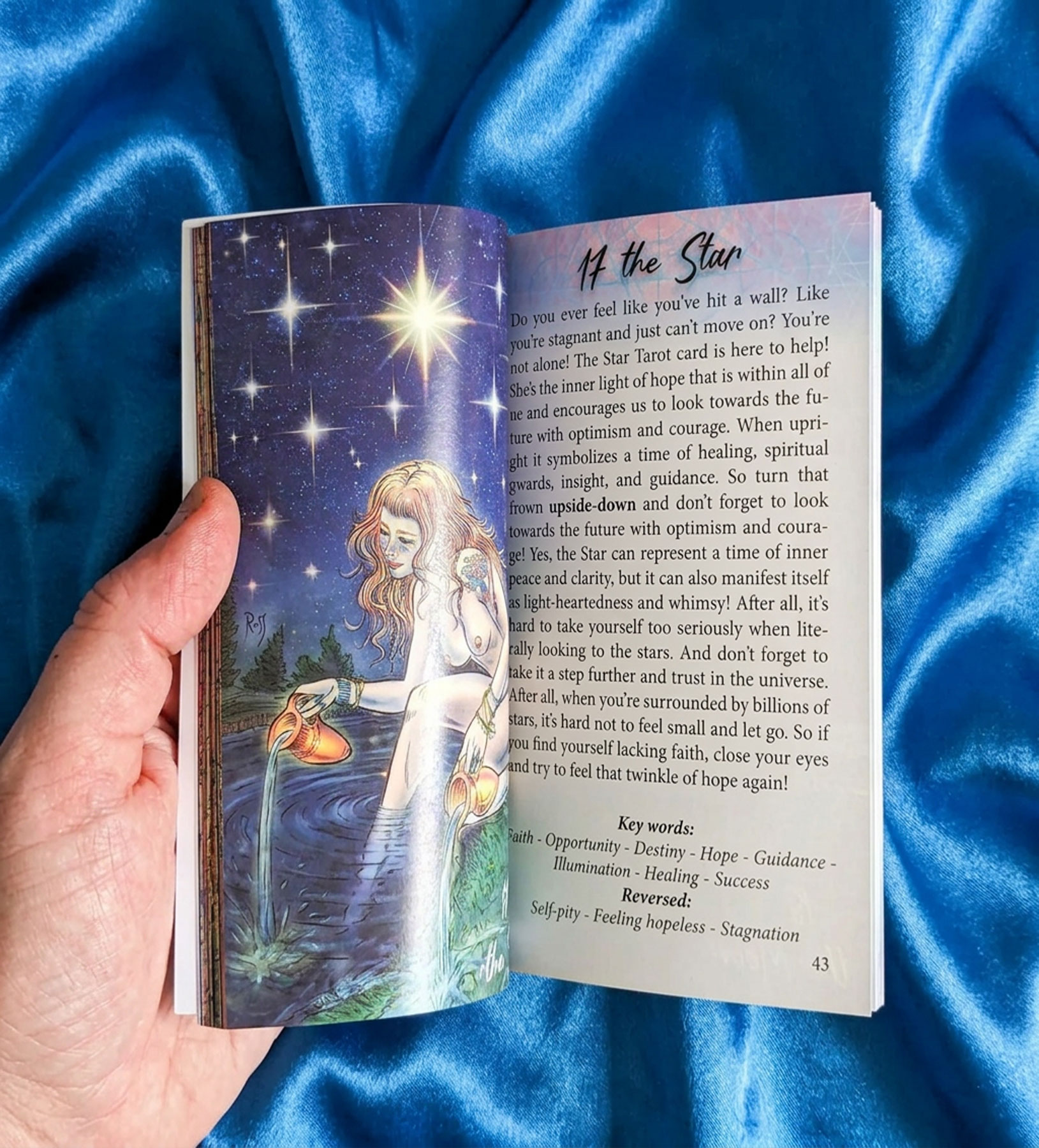 Guidebook open to The Star on blue silk