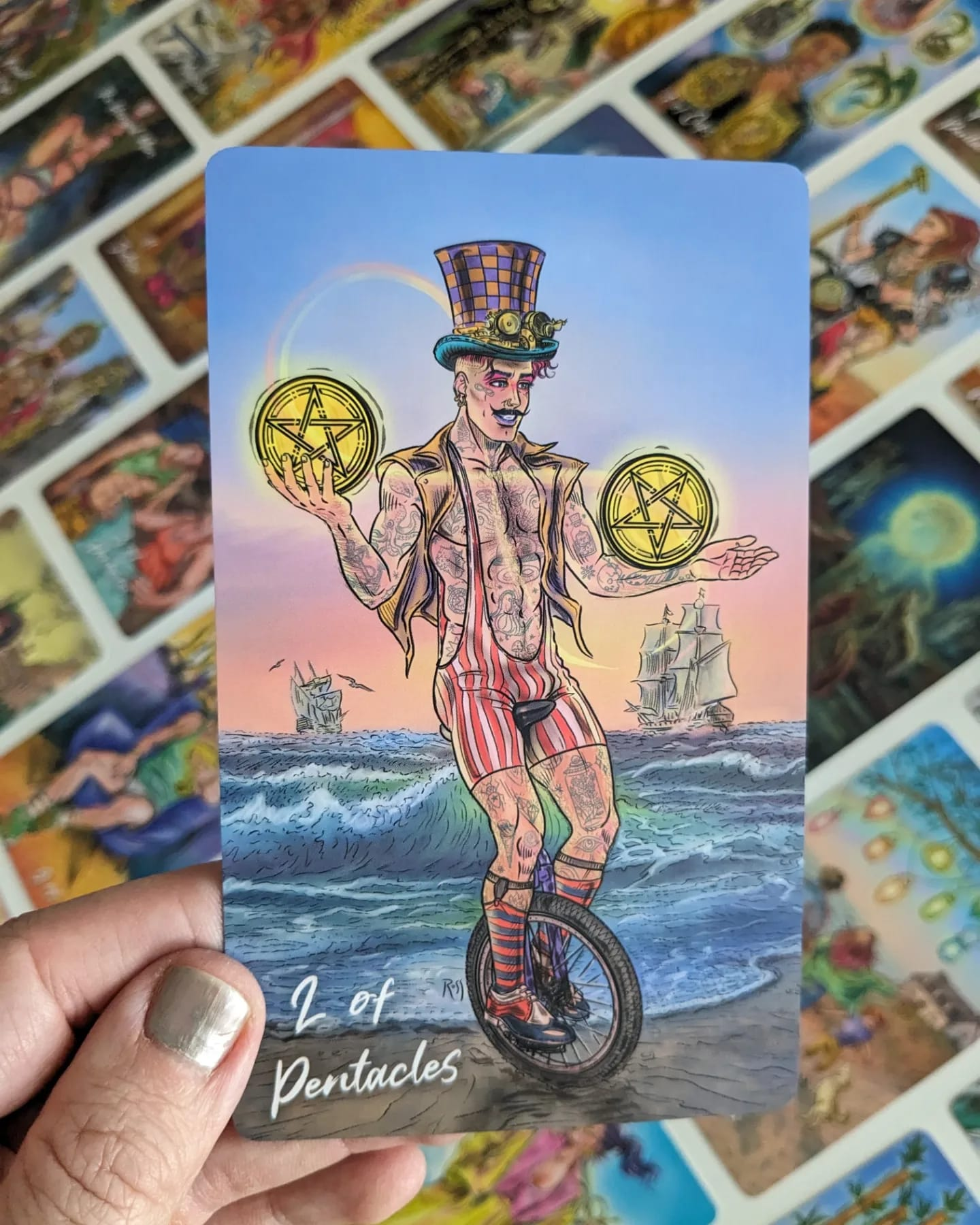 Two of Pentacles card held in front of a spread